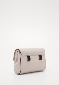 Quiltet lys rosa håndtaske med en slank rektangulær form. Har sorte hardware detaljer og en klaplukning. Glat tekstur.