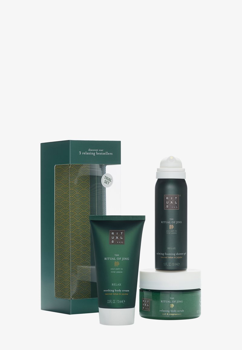 Eine grüne Box mit einem goldenen Wellenmuster, die drei Produkte enthält: eine Creme, ein Duschgel und einen Peeling, alle in eleganter, dunkelgrüner und weißer Verpackung.