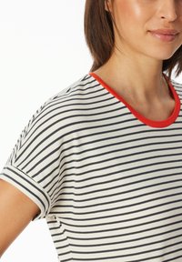 T-shirt a righe con strisce verticali blu marino e bianche, scollatura rossa, maniche corte e una morbida texture in cotone.