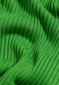 Tessuto verde a coste con una superficie texture, che mostra motivi verticali e un aspetto morbido e elastico.