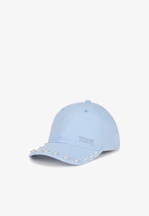 Gorra de béisbol azul claro con pequeñas perlas blancas a lo largo de la visera y "TOUS" bordado en el panel frontal.
