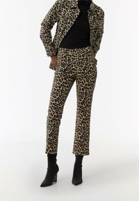 Beige en zwarte jas en broek set met luipaardprint, gemaakt van zachte stof, met een slim-fit ontwerp en vijf zakken. Zwarte enkellaarsjes.