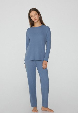Conjunto de loungewear suave y con relieve en azul claro, que incluye una camiseta de manga larga y pantalones a juego con un ajuste relajado. Tejido ligero y suave.