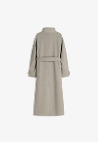 Lång grå kappa i mjukt tyg, med hög krage, bälte i midjan och vida ärmar. Ren linjedragning och minimal sömnadsdesign.