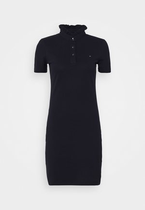 Czarna sukienka o krótkich rękawach sięgająca kolan, z falbanowanym wysokim kołnierzem, trzema guziczkami z przodu i małym logo na piersi.