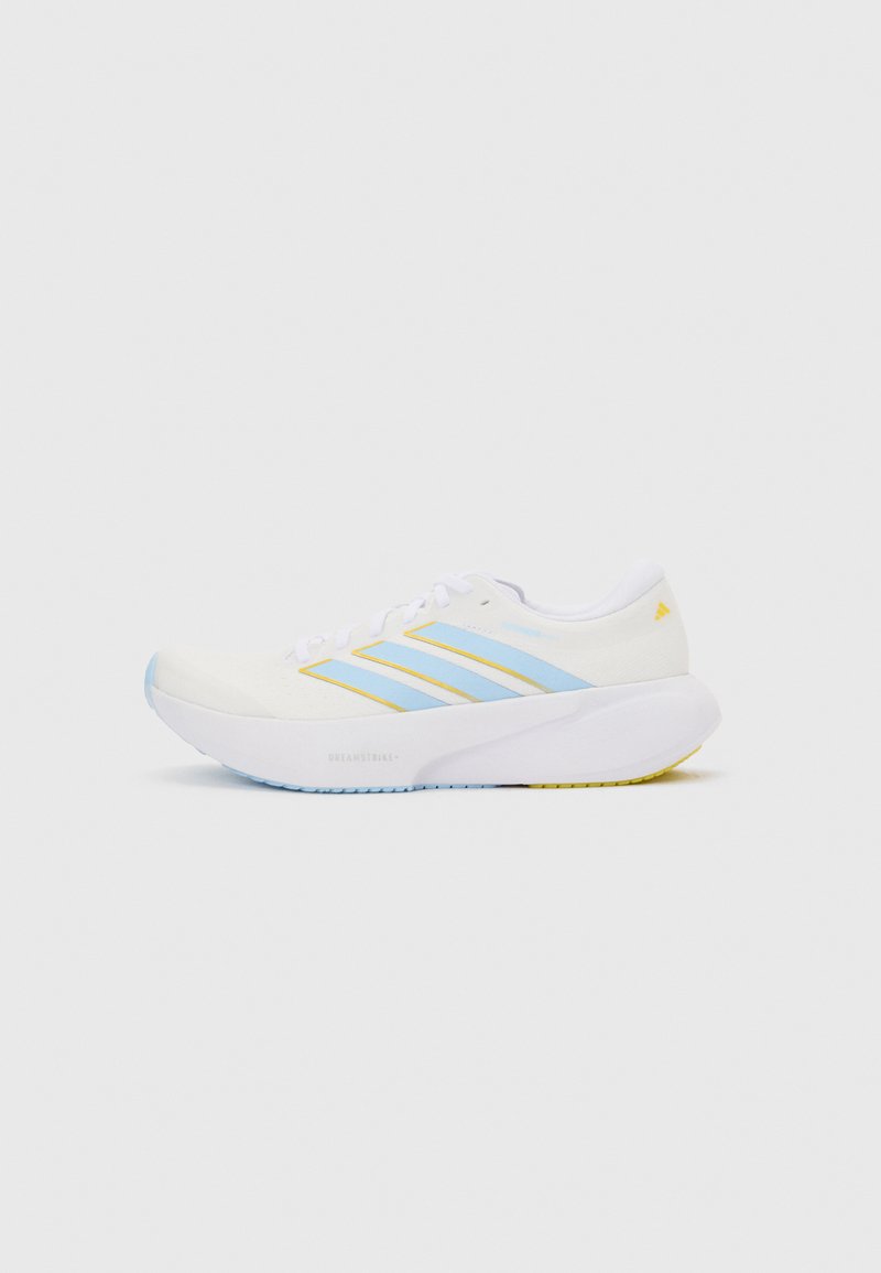 Λευκό αθλητικό παπούτσι με ανοιχτό μπλε ρίγες και κίτρινες λεπτομέρειες, χοντρή λευκή σόλα, εμφανίζεται σε προφίλ πλευρικής όψης σε απλό φόντο.