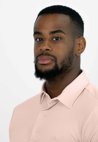 Helles rosa Polohemd mit Kragen, ausgestattet mit drei Knöpfen an der Knopfleiste und dezentem Logo-Stick auf der Brust.