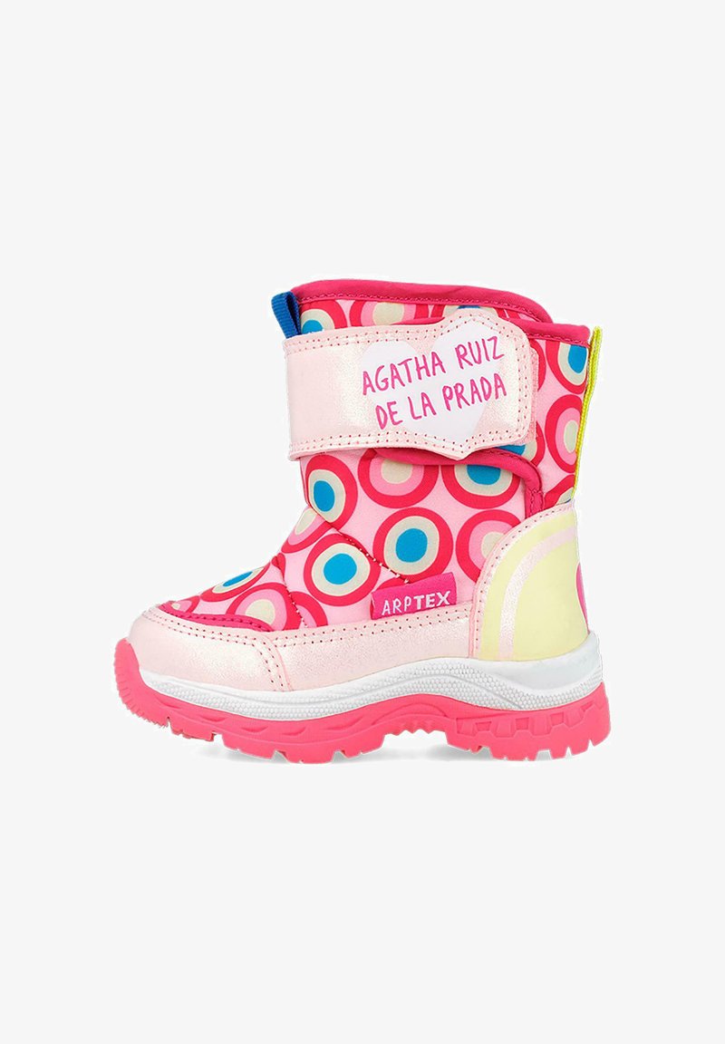 Botas de invierno rosas con patrones circulares de colores, suela de goma, tira de velcro y parte superior de tela. Etiqueta del fabricante visible en el lateral.