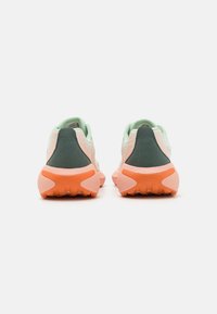 Zapatos ligeros con un empeine de malla verde menta, acentos en verde oscuro y suelas de goma en color rosa-naranja. Presentan acabados texturizados y soporte acolchado en el tobillo.