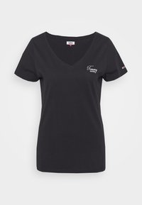 Černé tričko s krátkým rukávem a véčkovým výstřihem s malým bílým logem "Tommy Jeans" na hrudníku a vlajkovým emblémem na levém rukávu.