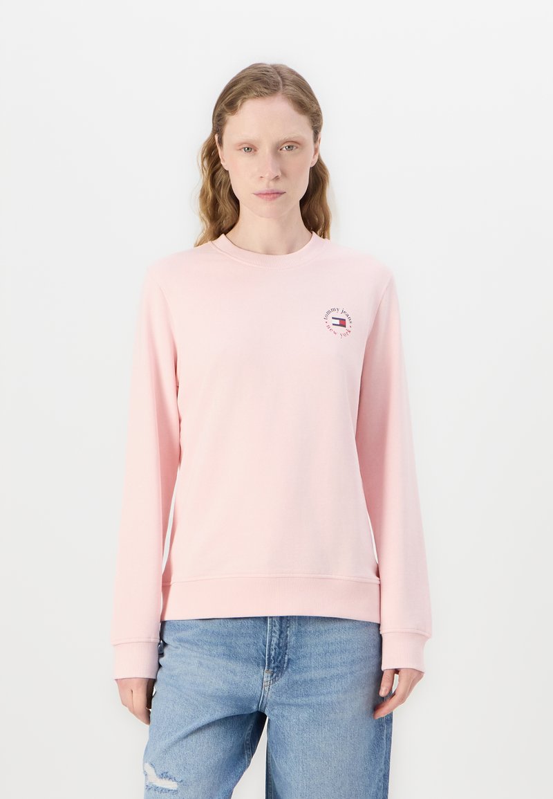 Felpa rosa chiaro con maniche lunghe, scollatura rotonda, polsini elasticizzati e orlo a coste. Presenta un logo circolare sul petto.