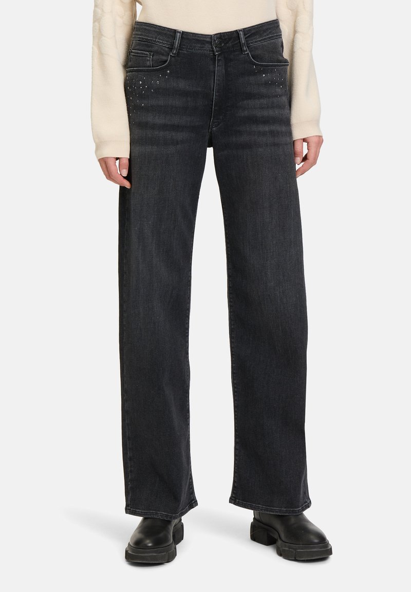 Szerokie jeansy z ciemnego denimu o wyblakłej teksturze, z ćwiekami na przednich kieszeniach i wysokim stanem.