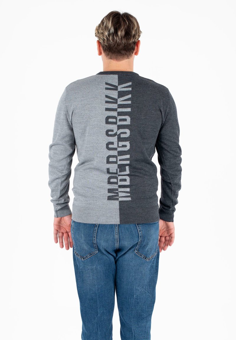 Szary i ciemnoszary sweter z pionowym wzorem tekstowym na plecach. Ściągacze na rękawach i u dołu, wykonany z gładkiego materiału dzianinowego.