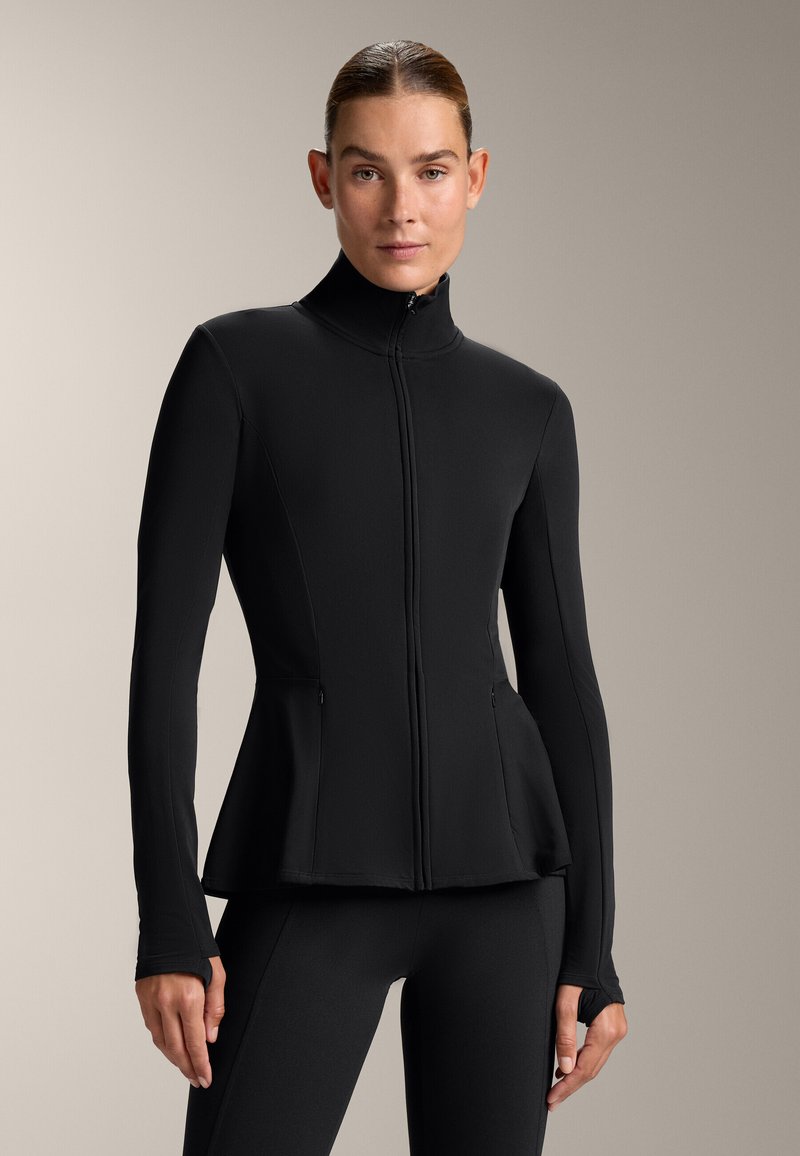 Black, fitted jacket with a high collar, front zipper, and side pockets. Features a peplum hem and long sleeves with thumbholes.