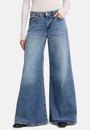 Wijd-uitlopende jeans van lichtblauwe denim met een vervaagde textuur. Heeft een traditionele vijf-pocketontwerp en een knoopsluiting bij de tailleband.