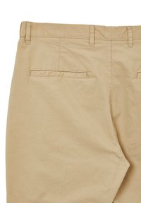 Pantaloni in cotone beige con una texture liscia, dotati di due tasche posteriori e cuciture a punto. La vita ha passanti per la cintura.