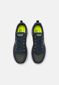 Le sneakers Skechers GOrun presentano una tomaia in rete blu navy con accenti giallo neon, una punta arrotondata e una suola in gomma imbottita.