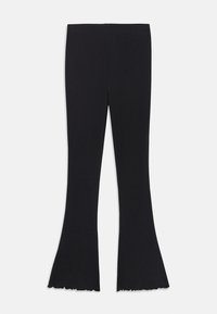 Leggings noires évasées avec des ourlets festonnés posées à plat sur un fond blanc.