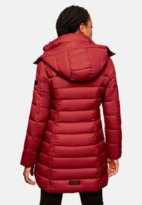 Red puffer coat featuring a hood, vertical quilting, and a slightly cinched waist. The material appears glossy with a soft texture.