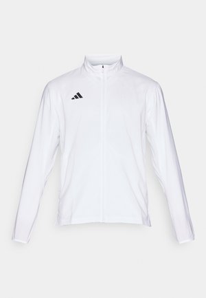 Chaqueta atlética blanca con mangas largas, cuello alto y cremallera completa. Presenta el logotipo de tres franjas en negro en la parte superior izquierda.