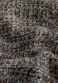 Tela tejida texturizada en tonos gris, marrón y beige; presenta un patrón de espiga con una sensación suave y pelusa, además de un detalle intrincado.