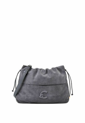 Bolso bandolera de ante gris suave con correa ajustable, laterales con cordón y un logo sutil en relieve en la parte frontal.