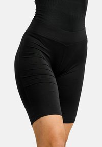 Schwarze elastische Biker-Shorts mit hohem Bund, glatter Textur und einer enganliegenden Passform, die bis zur Mitte des Oberschenkels reicht.
