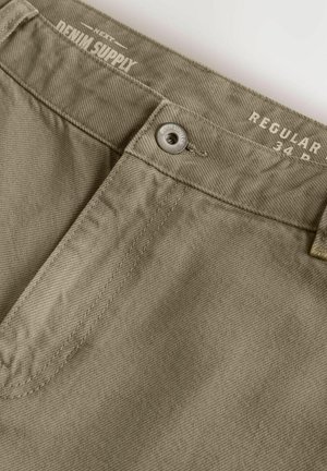 Khaki bawełniane spodnie o prostym kroju. Oferują metalowe zapięcie, detale przeszyć oraz logo "Denim Supply" na pasie.