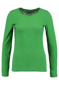 T-shirt verde a maniche lunghe realizzato in tessuto leggero, con scollatura rotonda e una consistenza morbida. Nessun motivo o decorazione visibile.