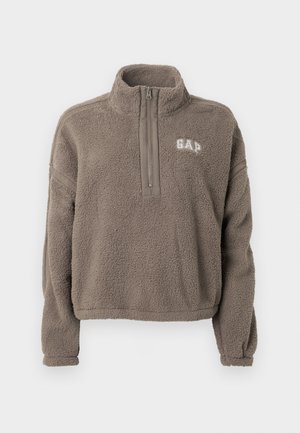 Fleecegenser i gråbrun med halvglidelåsfals. Har GAP-logo på brystet og elastiske mansjetter i ermene. Myk tekstur.