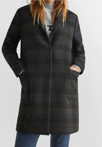 Cappotto a quadri scuri in misto lana, con colletto a punta, due tasche frontali e maniche lunghe. Colori grigio e carbone con finitura testurizzata.