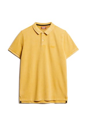 Polo-shirt en coton jaune à manches courtes, col côtelé, deux boutons, et logo brodé sur la poitrine. Présente un ourlet inférieur droit.