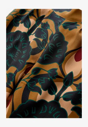 Floral fabric with brown, black, and green hues; features large leaves and flowers in a bold design, smooth texture and flowing drape.