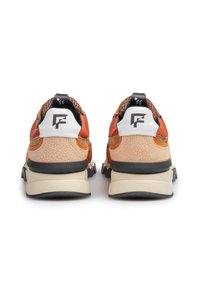 Scarpe da atletica arancioni e beige con un retro testurizzato, accenti neri e branding bianco sul tallone. Suola spessa con colori a contrasto.