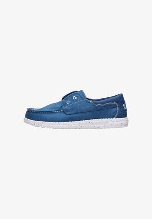 Blauer lässiger Slip-On-Schuh mit weißen Nähten, Ösen und einer gesprenkelten weißen Sohle, seitlich auf weißem Hintergrund dargestellt.
