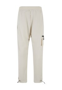 Pantaloni leggeri beige con elastico in vita, tasca laterale con zip e polsini regolabili con coulisse. Finitura in tessuto liscia e textured.