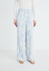 Wide-leg pants in a light cream color with blue abstract patterns. Features an elastic waistband. Made from a lightweight fabric.