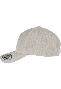 Šedá látková čiapka snapback s plochým ramenom, na prednej strane s čiernou kruhovou nášivkou a ventilačnými otvormi.