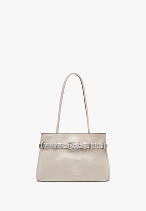Beżowa skórzana torba o usztywnionym kształcie, z akcentem w postaci srebrnej klamry na pasku i gładką fakturą. Dwie długie rączki do noszenia.