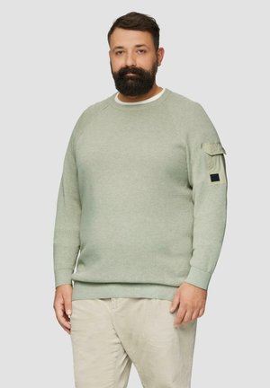 Lichtgroene gestructureerde sweatshirt met raglanmouwen, een ronde hals en een patchzak op de arm. Gecombineerd met lichtbeige corduroy broek.