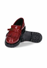 Mocassino rosso lucido con frange e dettaglio in fibbia dorata, suola nera robusta con un motivo di battistrada profondo, una scarpa in posizione verticale e l'altra con la suola rivolta verso l'alto.