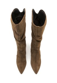 Une paire de bottes hautes en daim marron avec des pointes effilées et des tiges légèrement tombantes, présentées de haut sur un fond blanc.