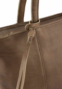 Bruine leren tote bag met een opvallende textuur en een geknoopte hengsel detail. Bevat een lichte accent rond de rand van de hengsels.
