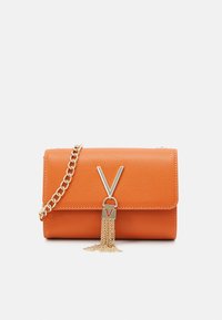 Orange texturerad läderclutch med ett spänne som har en guldkedja och en tofsdetalj. Inkluderar en avtagbar guldkedjestrap.
