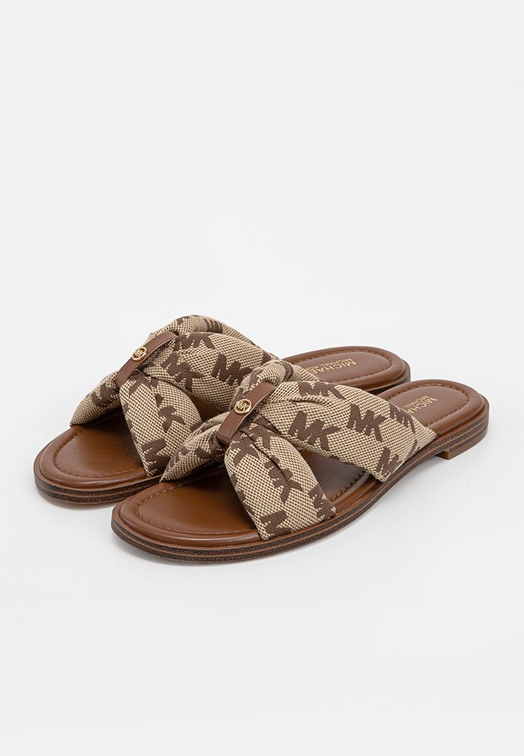 Beige Canvas-Slide-Sandalen mit Knoten-Design, braunem Lederfußbett und Logo-Akzent am Riemen. Flache Sohle, minimalistischer Stil.