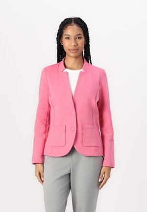 Blazer rose avec un design structuré, deux poches avant et une fermeture à un bouton, associé à un pantalon gris. Fini en tissu texturé.