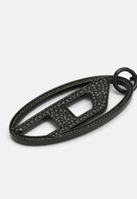 Portachiavi in metallo nero a forma ovale con un design intagliato, decorato con strass trasparenti e smoky su tutta la superficie.