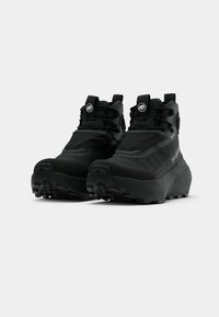 Black hiking boots with a textured upper, reinforced toe, and aggressive tread. Features include a high ankle silhouette and adjustable laces.