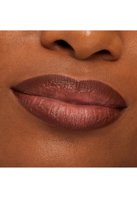 Close-up of dark brown lips with glossy, slightly shimmering lipstick and smooth dark skin around the mouth and nose.