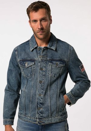 Denim jas in middentinten blauw met knoopsluiting, twee borstzakken, een geborduurd logo op de schouder en een klein Amerikaanse vlagpatch.